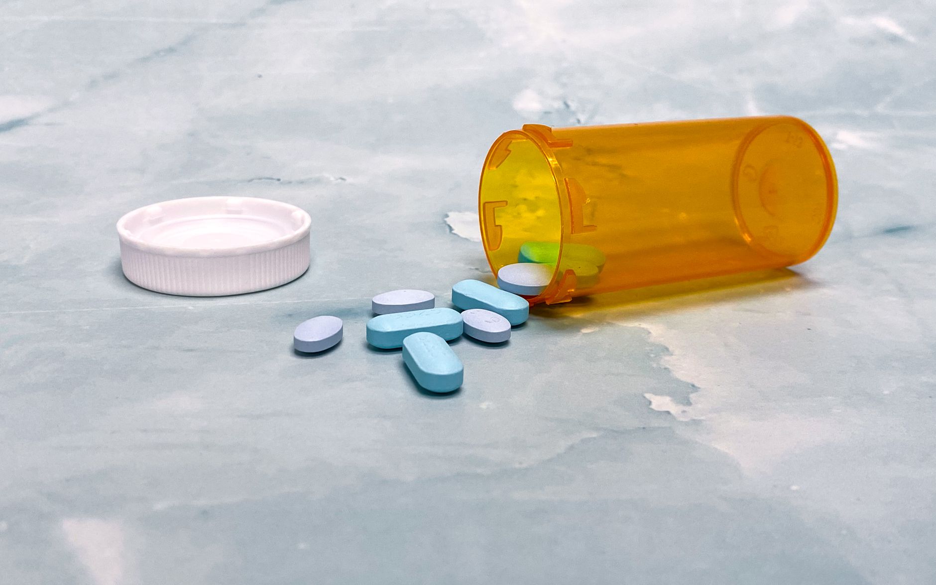 An open prescription bottle with tablets